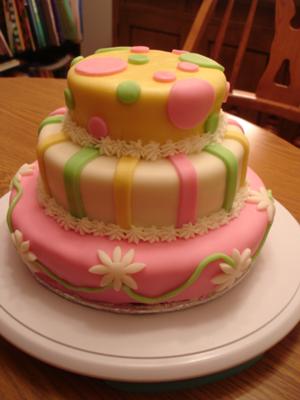 Photo of a cute yellow and pink polka dot daisy baby shower cake